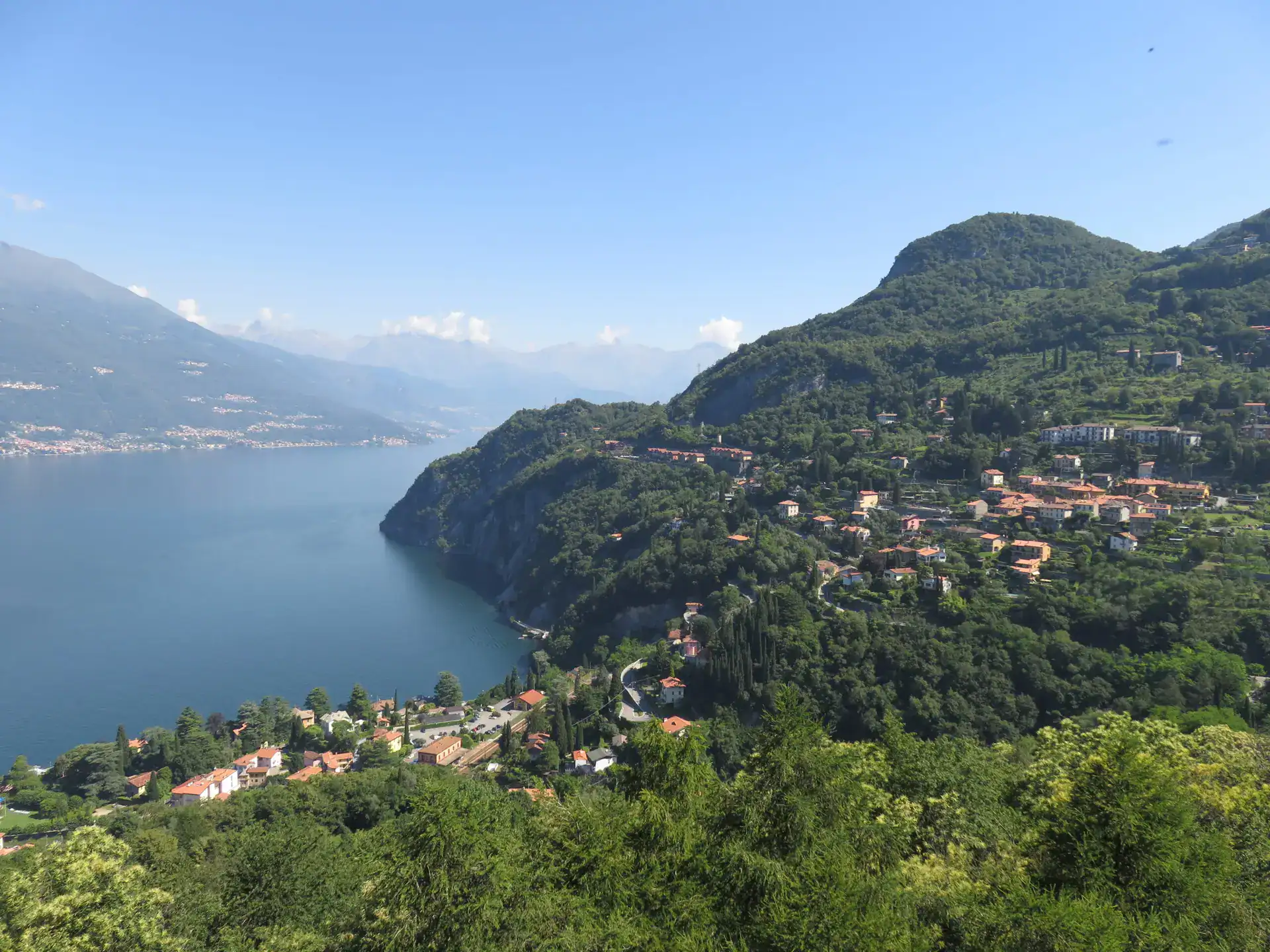 Beautiful mountain village overlooking a serene lake and lush greenery.